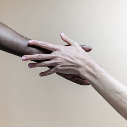 Mãos interraciais se tocando. A sociedade ocidental atribui peso maior ao indivíduo do que à família