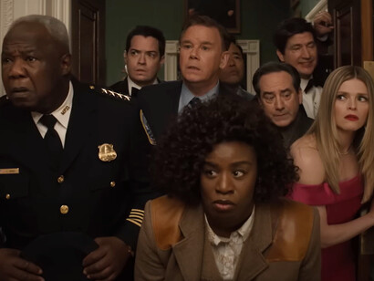 A tense group, led by Uzo Aduca as Detective Cordelia Cupp, leans in with wide-eyed curiosity and concern in The Residence, where every glance and whisper in the White House holds the weight of a deadly secret