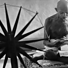 Margaret Bourke-White, Mohandas Karamchand Gandhi mentre legge vicino a un arcolaio nella sua casa di Pune. Maharashtra, India, 1946. Per gentile concessione di Margaret Bourke-White/The Life Picture Collection/Shutterstock