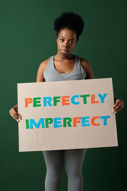 woman with a sign 'perfectly imperfect'