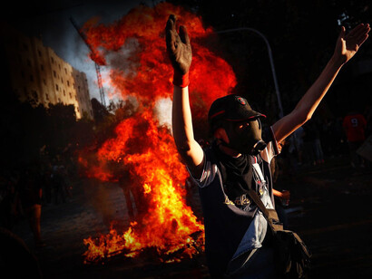 Manifestante frente a una hoguera durante en 'Estallido Social' de 2019 en Chile