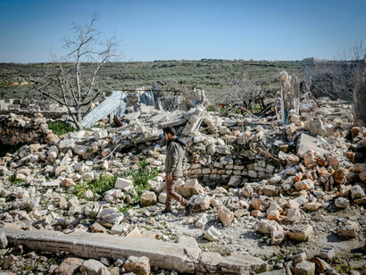 A man walking through the debris of a destroyed town