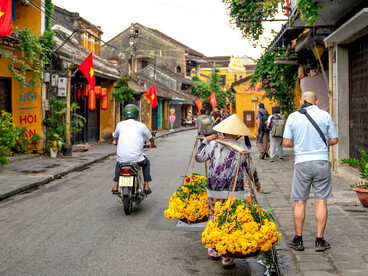 A vibrant street scene in Hoi An, Vietnam, featuring colorful lanterns, traditional architecture, and pedestrians exploring the historic town