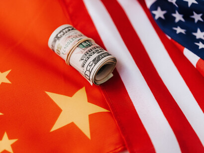 US flag, Chinese flag and a roll of money