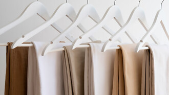 Light brown beige pants hanging on minimalist hangers, showcasing a sleek and simple style