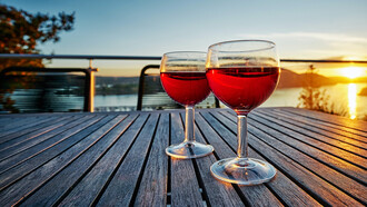 Dos copas de vino sobre una mesa durante el atardecer