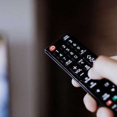 Un mando a distancia frente al televisor representa la relación cotidiana del público con los contenidos audiovisuales y la posibilidad permanente de cambiar de canal