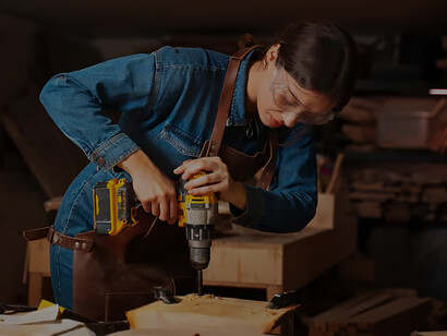 Capture the essence of empowerment with an image of a girl in the garage, engaged in woodcutting, showcasing determination and resourcefulness in pursuit of her goals