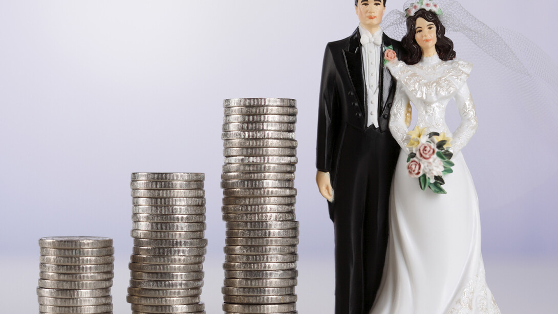 Dinero junto a las figuras de los novios de la tarta nupcial