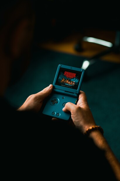 Person holding an old games console in a dark room 