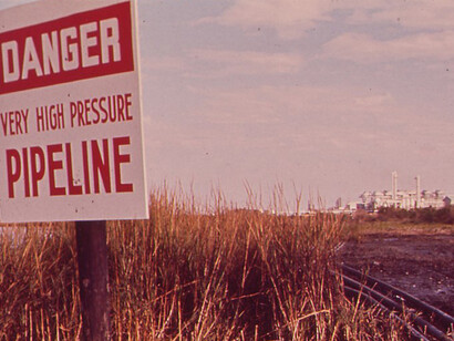 Pipelines from a natural gas facility, located in the background, run through Rattlesnake Bayou at the western end of the Freeport Sulphur Co. Pipeline Canal in New Orleans, Louisiana, United States