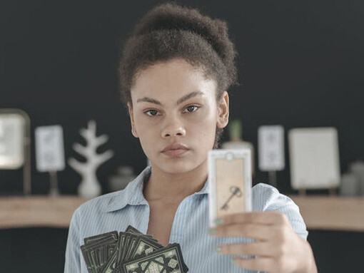 Holding the cards closely, she symbolises the shift from centralised power to community empowerment, embodying the Aquarian spirit of collective strength and foresight