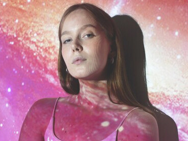 In a universe texture projection, a young woman represents the essence of feminine energy, symbolizing its transformative nature and cosmic connection