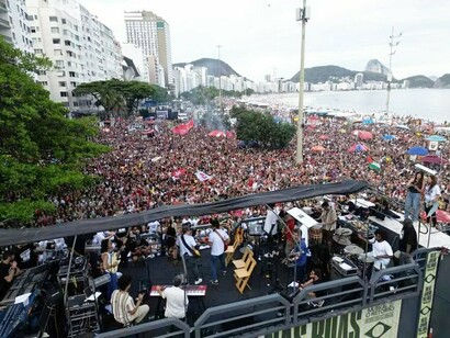 Manifestantes participam de um ato público no Rio de Janeiro com apresentações musicais e discursos em defesa da democracia. A mobilização reuniu pessoas contrárias ao projeto de lei que propunha anistia aos envolvidos nos atos de 8 de janeiro de 2023, iniciativa defendida por parlamentares de partidos como PL, PP, Republicanos, Novo e parte das bancadas de União Brasil e PSD