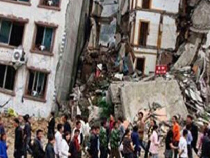 Los nepalíes caminan entre los edificios dañados por el seísmo