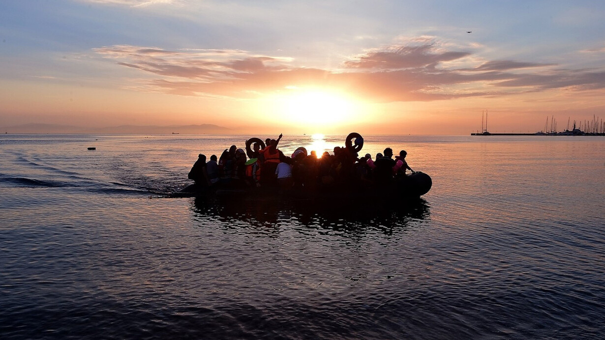 Syrian migrants in an overcrowded dinghy from Turkey arrive on the Greek island of Kos