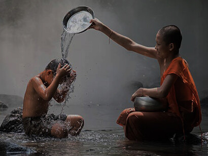 Young monks embrace the simple pleasures of life, laughing and splashing in the river during their bath