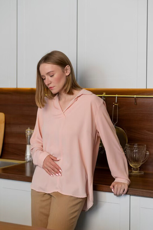 A woman holding her stomach in pain, illustrating the impact of the gut-brain axis and the role of probiotics in digestion