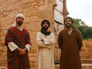 Three men standing together in traditional North African attire, representing cultural heritage and collective identity through dress