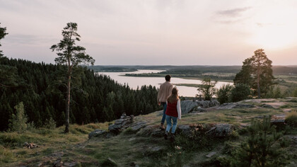 As the sun sets in the distance, a couple embraces the warmth of happiness that fills their hearts and minds, reminding them of the essential role serotonin plays in their well-being