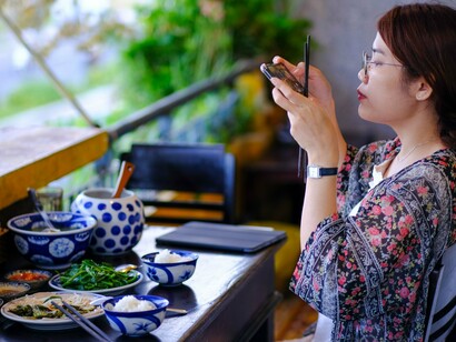 A visitor capturing an authentic dining experience, symbolizing the desire to preserve memorable culinary moment
