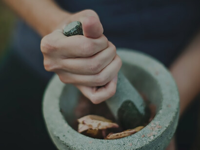 Person grinding on mortar and pestle