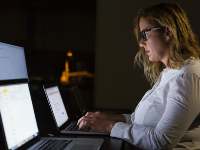 Team working together on computers in a dimly lit office environment