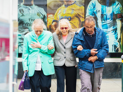 Three elderly people take a walk together in the city