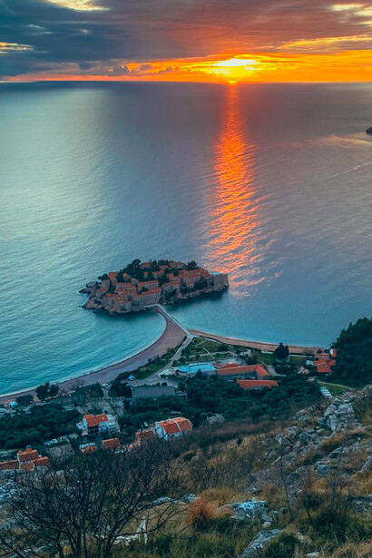 Experience the breathtaking beauty of Sveti Stefan island, Montenegro, bathed in the warm glow of sunset