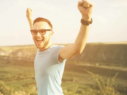 Una persona alza le braccia al cielo in un gesto di libertà o celebrazione
