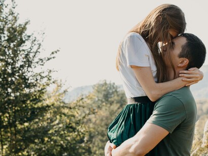 A woman being carried by her partner in a romantic embrace