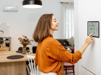 Mujer configurando los parámetros de una «casa inteligente»