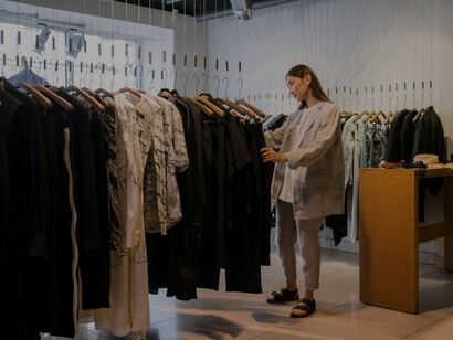 A woman exploring fashion pieces in a contemporary, high-end store