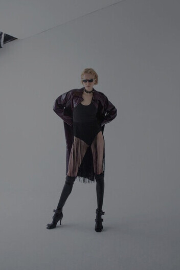 A model poses with sunglasses, showcasing designer brands and luxury contemporary fashion