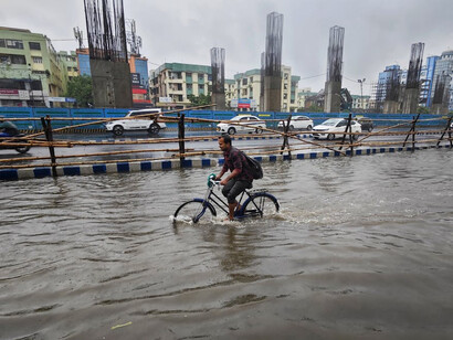 A man riding his bike through a flooded street