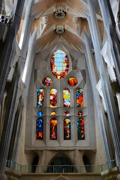 The richly decorated interior of La Sagrada Família in Barcelona, Spain, captivates visitors with its elaborate details and harmonious integration of nature-inspired elements
