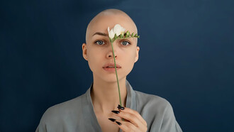A woman with cancer holding flowers in her hand