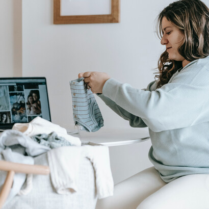 Mulher organiza as roupas infantis que já não servem mais para o filho