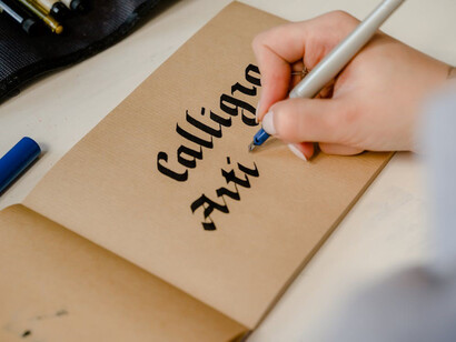 A person engaged in writing on brown paper