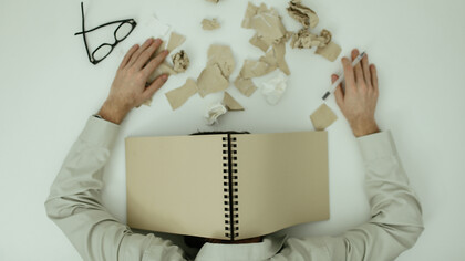 Trabalhador exausto debruça sobre a mesa de trabalho