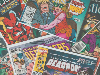 A stack of colorful comic books rests neatly atop a polished wooden table