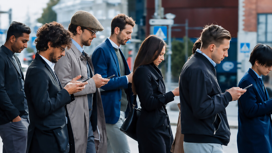 Smartly dressed professionals walk past a modern glass office building, absorbed in their smartphones and seemingly disconnected from the people around them