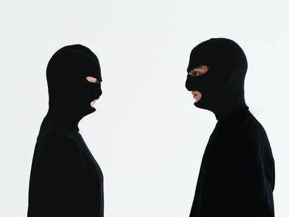 Duas pessoas ocultam suas identidades utilizando balaclavas