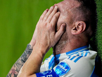 Argentina superstar Lionel Messi covering his face with his hand in pain