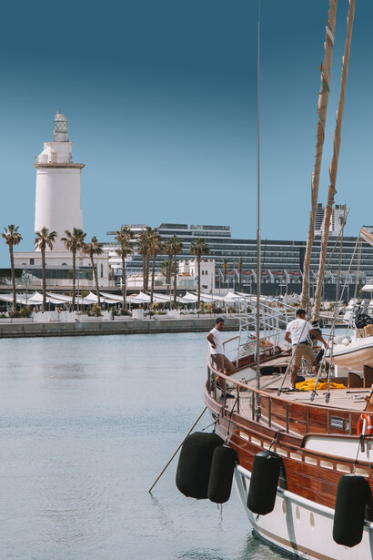 Barco atracado em frente ao farol do porto de Málaga, Espanha