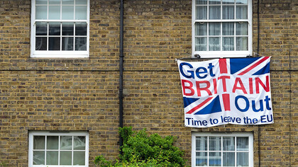 A brown brick building in the United Kingdom with a white fabric banner reading "Get Britain Out, Time to Leave the EU," reflecting the sentiment of the Brexit movemen