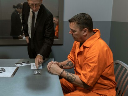 Man in a jump suit observes police evidence