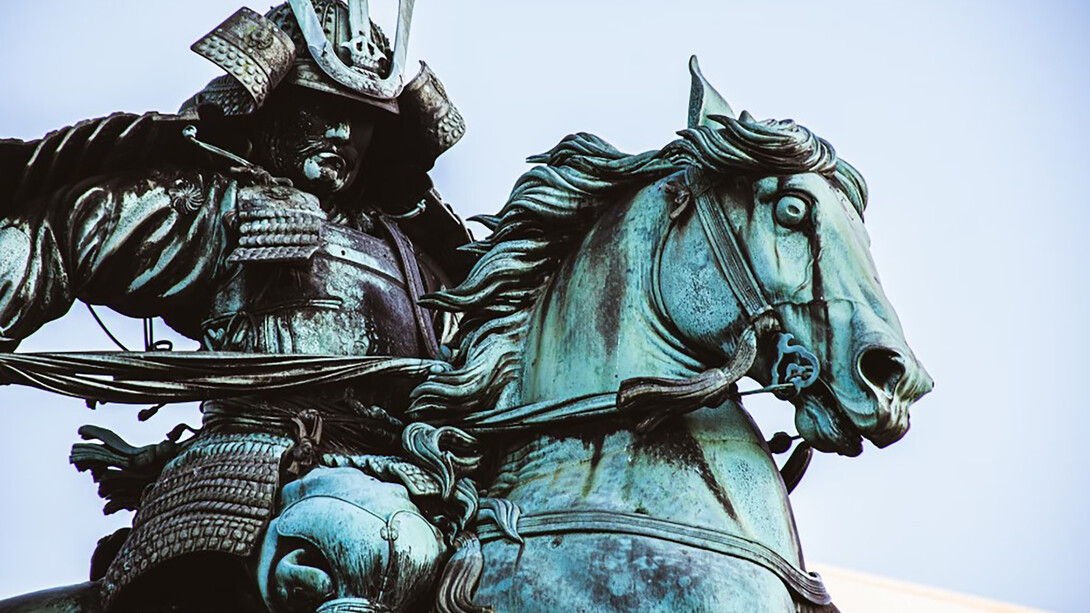 A statue of a man riding a horse, depicting a samurai in traditional Japanese armor