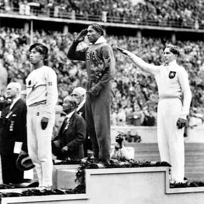 Il giapponese Naoto Tajima, terzo classificato, lo statunitense Jesse Owens, primo classificato e Lutz Long della Germania, che ha ottenuto il secondo miglior risultato alla premiazione per il salto in lungo ai Giochi Olimpici di Berlino 1936