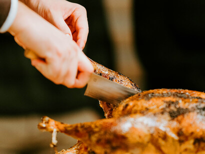 A traditional Christmas gathering, where a deliciously roasted chicken takes center stage at the family dinner table, filled with laughter and holiday spirit